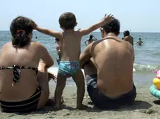 Una famiglia al mare sulla spiaggia in una immagine di archivio.Si chiamerà 'quoziente familiare'' o 'fattore famiglia' ma il governo interverrà per un nuovo fisco a misura di famiglia che tenga conto del numero dei componenti del nucleo familiare. In modo che "famiglie con figli o con situazioni di fragilità possano ricevere un concreto ed indispensabile aiuto in termini di riduzione della pressione fiscale e di accesso agevolato ai servizi". Lo ha ha annunciato oggi 8 novembre 2010 il sottosegretario alla Presidenza del Consiglio Carlo Giovanardi all'apertura della Conferenza nazionale della famiglia. FRANCESCA RUGGIERI / ANSA /