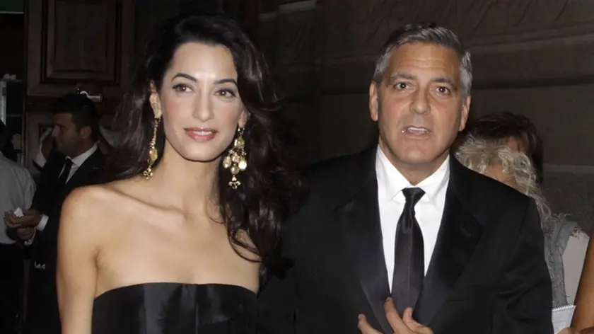 George Clooney and his fiancee Amal Alamuddin arrive for the "Celebrity Fight Night" foundation gala dinner, in Florence, Italy, Sunday, Sept. 7, 2014. (AP Photo/Francesco Bellini)