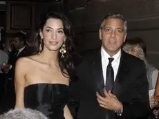 George Clooney and his fiancee Amal Alamuddin arrive for the "Celebrity Fight Night" foundation gala dinner, in Florence, Italy, Sunday, Sept. 7, 2014. (AP Photo/Francesco Bellini)