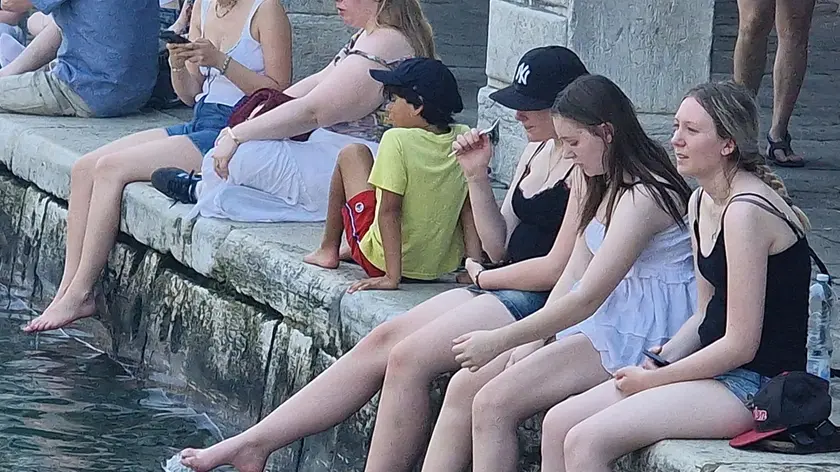 Turisti con i piedi nel canale