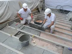 Restauratori al lavoro sulla scalinata del ponte (foto Agenzia Interpress)