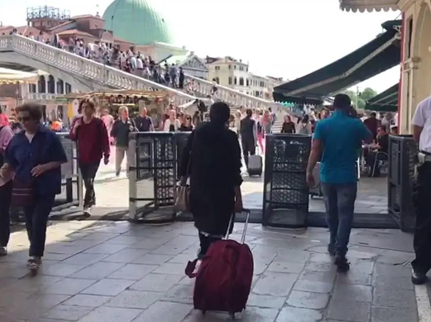 Sono stati installati oggi pomeriggio a Venezia i primi tornelli in metallo che serviranno da questo week end per fermare e deviare i turisti nel caso di eccessivo afflusso, 27 aprile 2018. Sarà la polizia municipale, in base all'ordinanza del sindaco, a decidere quando scatterà il blocco: i tornelli - uno vicino al Ponte di Calatrava, l'altro all'imbocco di lista di Spagna - daranno sempre via libera ai residenti, si chiuderanno invece per i turisti diretti a San Marco o Rialto, che verranno deviati su itinerari alternativi..ANSA/GABRIELE VATTOLO