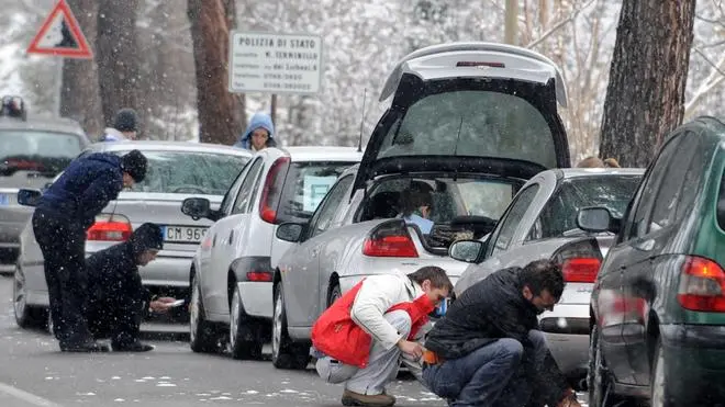 20081228 - RIETI - CRO : MALTEMPO: ANAS, NEVE SU STRADE CENTRO-SUD, TRAFFICO REGOLARE...Automobilisti mettono le catene per la neve alle ruote delle loro automobili oggi a Rieti... Neve non solo al nord e al centro ma anche sulle strade del centro-sud. Nevica, dunque, dall'Emilia Romagna alla Calabria, ma l'Anas non segnala particolari disagi sulla rete stradale. Il personale Anas, informa una nota, ''e' in attivita' 24 ore su 24 in tutta la Penisola per garantire la circolazione, in stretta collaborazione con la Protezione civile, la Polizia stradale e i Carabinieri''. Neve o nevicate in corso, ma con traffico regolare o rallentato, sono segnalate in particolare sulle diverse strade statali di Abruzzo, di Calabria, Campania, Lazio, Marche, Molise, Umbria e Toscana. L'Anas ricorda che in caso di nevicata in corso e' sempre obbligatorio, su tutta la rete, il transito con catene montate o pneumatici da neve...EMILIANO GRILLOTTI / ANSA / PAL