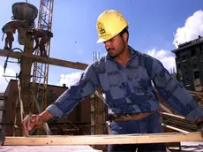 Un operaio egiziano al lavoro in un cantiere nel centro di Milano in una foto d'archivio. ANSA / DANIEL DAL ZENNARO