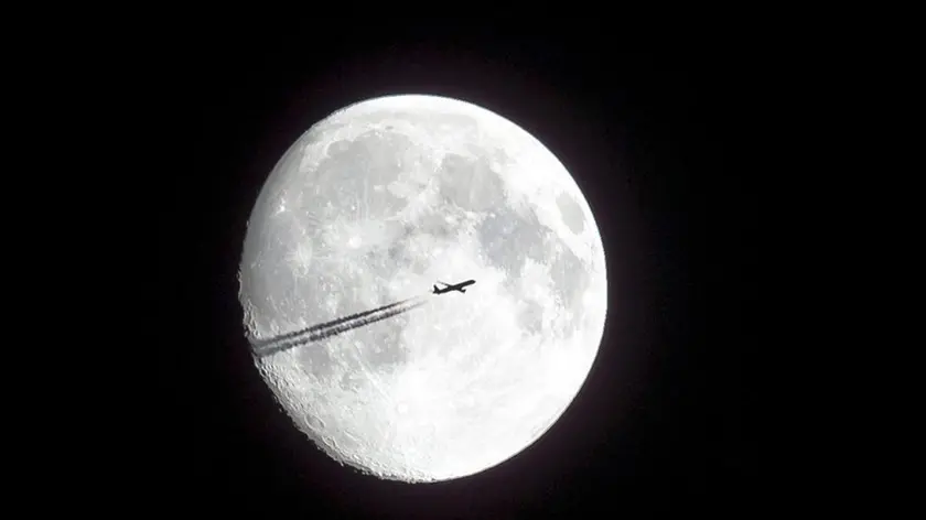 epa04346762 A plane is silhouetted against the moon as it is seen from Kalchreuth, Germany, 08 August 2014. EPA/DANIEL KARMANN