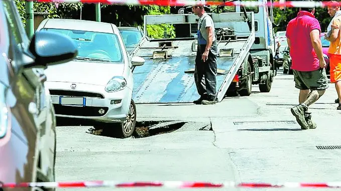 L'intervento per recuperare la Fiat Punto che stava per finire nella voragine (foto Candussi)