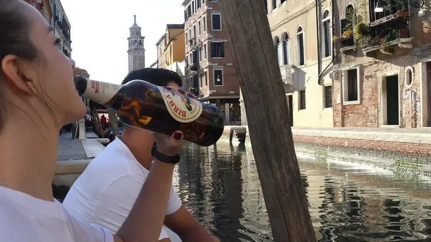 Interpress/M.Tagliapietra Venezia 24.09.2018.- Ragazza beve una birra seduta su una riva.