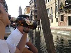 Interpress/M.Tagliapietra Venezia 24.09.2018.- Ragazza beve una birra seduta su una riva.