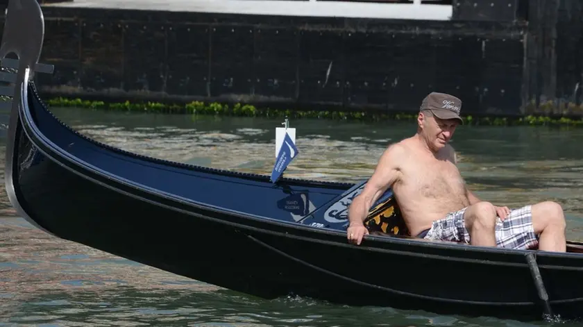 Interpress/M.Tagliapietra Venezia 24.06.2016.- Turista in gondola a torso nudo. Canal Grande Rialto.