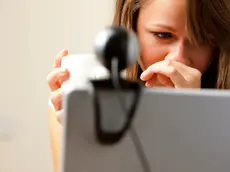 UK --- Close up of a woman using laptop computer with web cam --- Image by © Julian Winslow/ableimages/Corbis