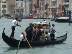 Gondolieri traghettano residenti e turisti dallo stazio di Santa Sofia a Rialto, in un'immagine di repertorio..ANSA/ANDREA MEROLA