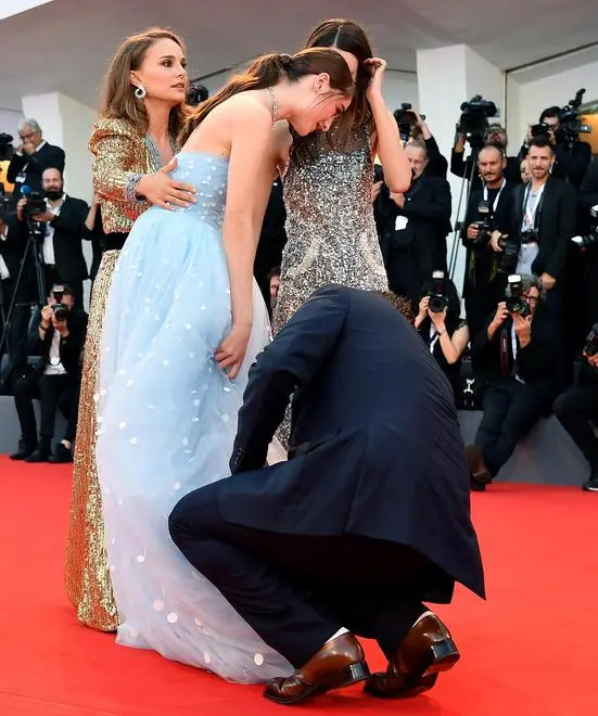 Director Brady Corbet (R-down), actress Natalie Portman (L) and actress Stacy Martin (R) assist actress Raffey Cassidy with her dress as they arrive for the premiere of 'Vox Lux' at the 75th annual Venice International Film Festival, in Venice, Italy, 04 September 2018. The movie is presented in official competition 'Venezia 75' at the festival running from 29 August to 08 September. ANSA/ETTORE FERRARI