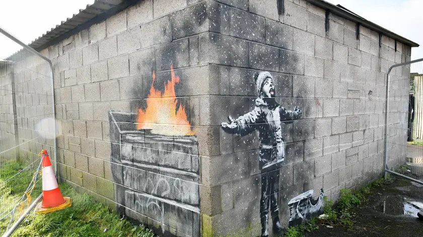 Un’opera di Banksy su un muro ad angolo