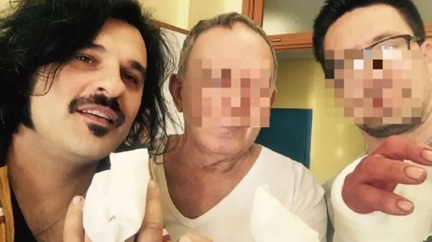 Mauro Marin, con due compagni di stanza in ospedale, mostra la mano operata