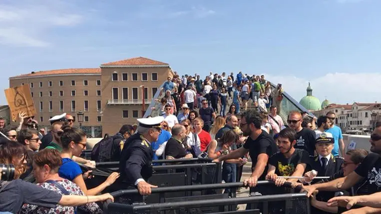 Un gruppo di appartenenti al Centro sociale Morion protesta davanti ad uno dei due varchi, ai piedi del Ponte di Calatrava a piazzale Roma, voluti dal comune per limitare gli ingressi ai turisti a Venezia, 29 aprile 2018. .ANSA