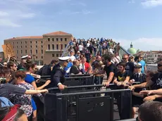 Un gruppo di appartenenti al Centro sociale Morion protesta davanti ad uno dei due varchi, ai piedi del Ponte di Calatrava a piazzale Roma, voluti dal comune per limitare gli ingressi ai turisti a Venezia, 29 aprile 2018. .ANSA