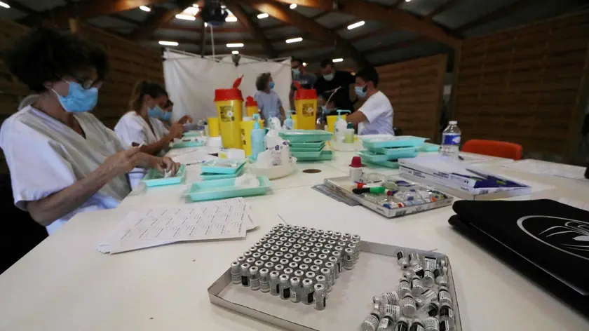 Health workers prepare syringes containing a dose of a Covid-19 vaccine at a vaccination centre in Perpignan, southern France, on July 18, 2021. - French authorities said on July 16 that face masks will again be required in all public spaces indoors and out in a southern region bordering Spain, after Covid infections soared this week because of the more infectious Delta variant. The Pyrenees-Orientales department now has the highest Covid incident rate in France at 257 per 100,000 people, up from 130 on Monday -- well above the alert level of 50. (Photo by RAYMOND ROIG / AFP)