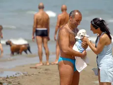 Asciugamano dopo il 'bagnetto' per un cucciolo allo stabilimento Baubeach di Maccarese (Roma). Il solleone estivo mette a dura prova anche gli animali da compagnia, e, col caldo di questi giorni, portare Fido in spiaggia nelle diverse bau-beach delle coste italiane puo' presentare dei rischi. ''Gli animali da compagnia - sottolineano i veterinari Enpa (Ente nazionale protezione animali) e Anmvi (Associazione nazionale medici veterinari italiani), sul sito www.vacanzebestiali.org - non hanno esigenze molto diverse da quelle dell'uomo. L'esposizione al sole e all'afa e' un fattore di rischio anche per loro''. ETTORE FERRARI/ANSA