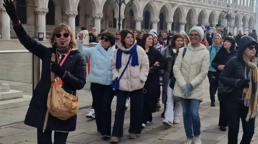 Una guida turistica accompagna una comitiva in piazza San Marco