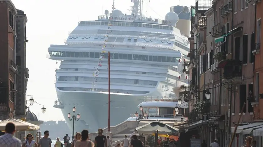 La prua di una grande nave da crociera torreggia all'ingresso di via Garibaldi, nel sestiere di Castello, a nord del centro storico di Venezia, 8 luglio 2011. Così appare ai passanti mentre la meganave è impegnata a curvare verso il Lido, in direzione della bocca di porto di San Nicolò ed il mare aperto. Italia Nostra ha denunciato la pericolosità per Venezia di questo genere di traffico marittimo. .ANSA/ANDREA MEROLA