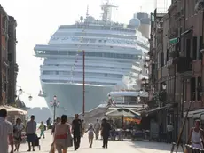 La prua di una grande nave da crociera torreggia all'ingresso di via Garibaldi, nel sestiere di Castello, a nord del centro storico di Venezia, 8 luglio 2011. Così appare ai passanti mentre la meganave è impegnata a curvare verso il Lido, in direzione della bocca di porto di San Nicolò ed il mare aperto. Italia Nostra ha denunciato la pericolosità per Venezia di questo genere di traffico marittimo. .ANSA/ANDREA MEROLA