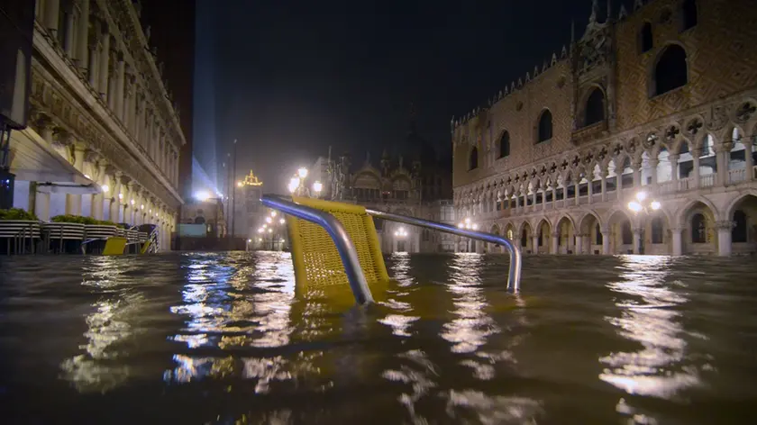 La sedia di un caffe' di piazza San Marco a Venezia affiora dall'acqua alta che, nelle prime ore di stamattina, 24 dicembre 2010, ha raggiunto il livello di 144 cm sul medio mare. ANSA/ ANDREA MEROLA