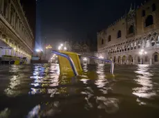 La sedia di un caffe' di piazza San Marco a Venezia affiora dall'acqua alta che, nelle prime ore di stamattina, 24 dicembre 2010, ha raggiunto il livello di 144 cm sul medio mare. ANSA/ ANDREA MEROLA