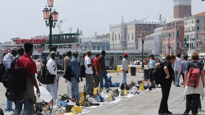 Una foto d'archivio di venditori ambulanti abusivi lungo riva degli Schiavoni a Venezia. ANSA / ANDREA MEROLA