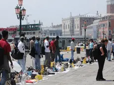 Una foto d'archivio di venditori ambulanti abusivi lungo riva degli Schiavoni a Venezia. ANSA / ANDREA MEROLA