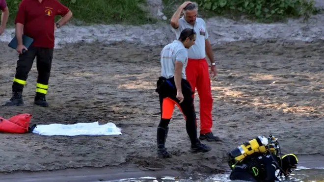 Sommozzatori impegnati nelle ricerche dei corpi dei tre ragazzini scomparsi nelle acque dell'Adige in località Marice, a Cavarzere (VE), 12 agosto 2013. Il corpo di uno dei tre giovani e' stato recuperato nel fiume. ANSA/ANDREA MEROLA