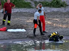 Sommozzatori impegnati nelle ricerche dei corpi dei tre ragazzini scomparsi nelle acque dell'Adige in località Marice, a Cavarzere (VE), 12 agosto 2013. Il corpo di uno dei tre giovani e' stato recuperato nel fiume. ANSA/ANDREA MEROLA