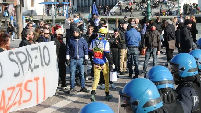 Interpress/Mazzega Pellicani Venezia, 08.03.2014.- Piazzale S.Lucia, momenti di tensione tra Centri Sociali e Forza Nuova.- Nella foto un neolaureato passa tra le forze dell'ordine e gruppi speciali con il sedere nudo