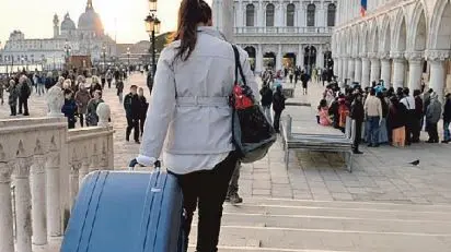 Una turista con il trolley, una consuetudine a Venezia