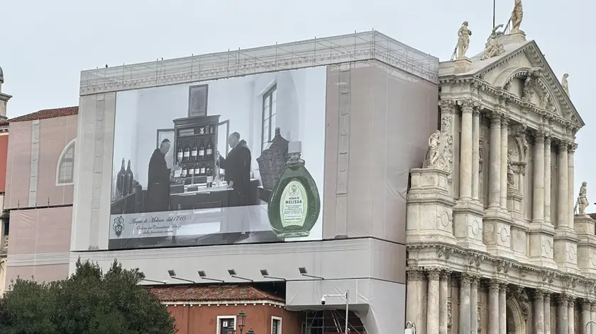 La grande pubblicità sulle impalcature del cantiere di restauro della chiesa degli Scalzi, dov'è nato il rimedio naturale