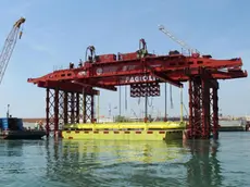 Una immagine dell'installazione della prima paratoia del Mose, Venezia, 14 giugno 2013. Posizionata ieri nel canale di Lido-Treporti, sono iniziate le operazioni di varo: la paratoia è stata lentamente calata in acqua per essere installata nel "cassone" di alloggiamento sott'acqua tramite uno speciale "mezzo di varo". ANSA / US CONSORZIO VENEZIA NUOVA ++NO SALES EDITORIAL USE ONLY++