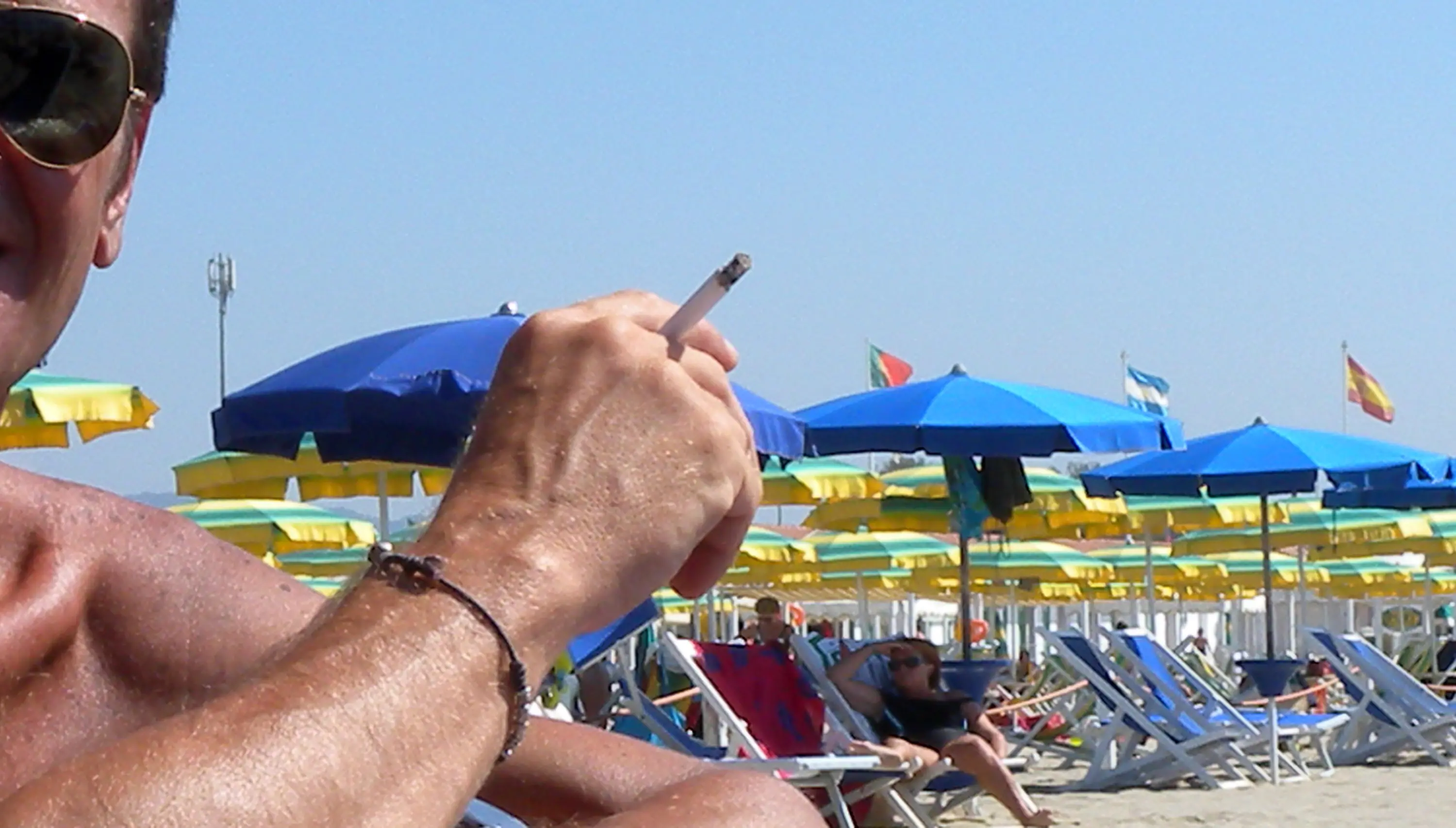 Un ragazzo fuma una sigaretta sulla spiaggia in una foto d'archivio. ANSA/FRANCO SILVI