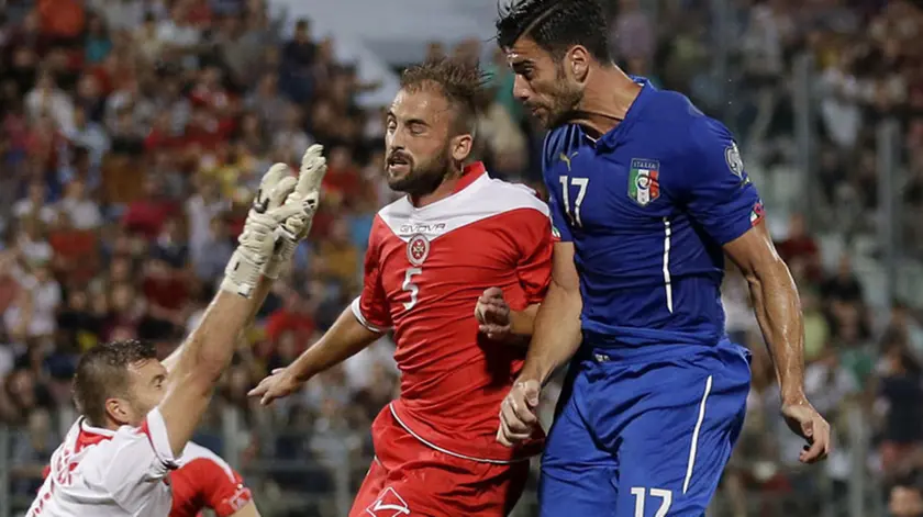 Italy’s Graziano Pelle, right, tries to scores as Malta goalkeeper Andrew Hogg, left, and Malta’s Andre Agius go to stop him during the Euro 2016 qualifying soccer match between Malta and Italy, at the National Stadium Ta' Qali, in Valletta, Malta, Monday, Oct. 13, 2014. (AP Photo/Antonio Calanni)