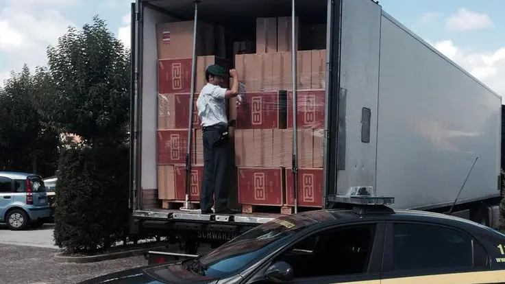 Finanzieri davanti al Tir con nove tonnellate di sigarette di contrabbando, del valore di oltre un milione di euro, scoperto dalla Guardia di finanza a Teano (Caserta), in un'area di servizio dell'autostrada Roma-Napoli, 1 agosto 2014. ANSA / US GDF NAPOLI ++NO SALES EDITORIAL USE ONLY++