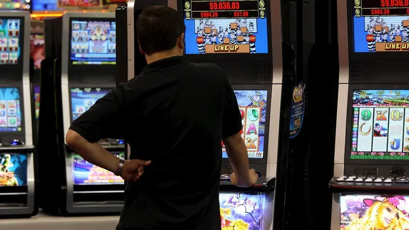 Un uomo gioca con una slot machine in una foto d'archivio. ANSA / YM YIK .