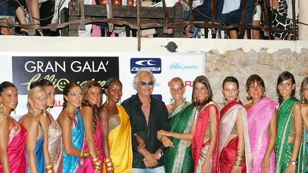 20090808 - ROMA - CLJ - ESTATE: BILLIONAIRE, TROPPA GENTE DENTRO E SCATTA DENUNCIA. Flavio Briatore (C) posa per una foto durante una festa al Billionaire, in una immagine di archivio. Il quadruplo della gente consentita all'interno del Billionaire, il locale smeraldino di Flavio Briatore. Lo hanno accertato, durante un controllo effettuato ieri sera, i Carabinieri che hanno contato all'interno ben 400 persone invece delle cento che la licenza consente. E' scattata cosi' la denuncia alla magistratura che potrebbe portare al sequestro del locale. I Carabinieri, in borghese, hanno fatto la fila come normali clienti e una volta verificata la situazione all'interno del locale che svetta sulla collina di Pantogia, si sono qualificati e hanno contestato all'amministratore delegato della societa' che gestisce il locale, Paolo Azara, l'apertura abusiva di luogo di pubblico spettacolo. ANSA/DAVIDE CAGLIO