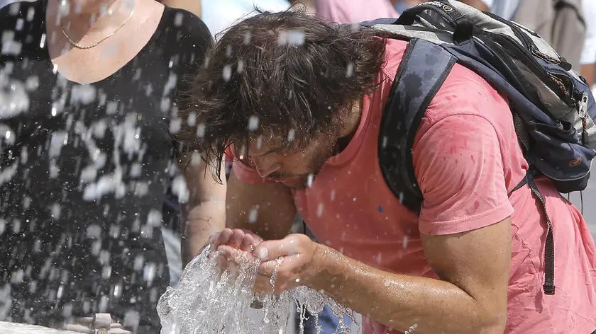 Turisti cercano refrigerio dall'alta temperatura e dall'afa in piazza San Pietro in Vaticano, 22 luglio 2015..ANSA/GIUSEPPE LAMI