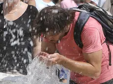 Turisti cercano refrigerio dall'alta temperatura e dall'afa in piazza San Pietro in Vaticano, 22 luglio 2015..ANSA/GIUSEPPE LAMI