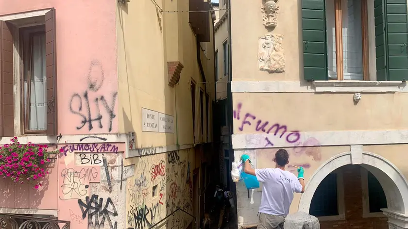 Operai al lavoro per ripulire le scritte sul palazzo di San Canzian