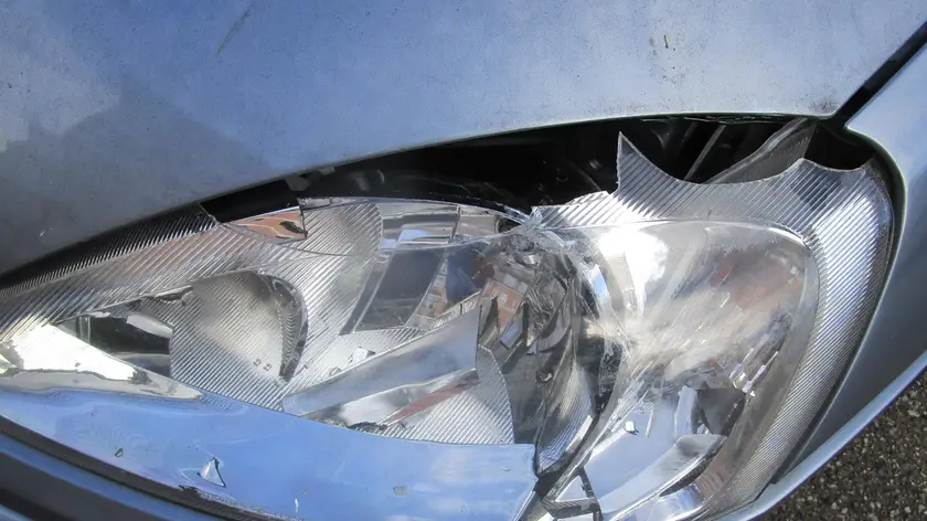 Il fanale in frantumi dell'auto presa di mira dai vandali