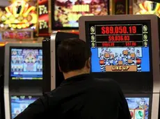 Un uomo gioca con una slot machine in una foto d'archivio. ANSA / YM YIK .