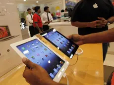 A prospective buyer compares the new iPad tablet computer, left, with the older version at a store in Bangalore, Friday, April 27, 2012. Sales of Apple's new iPad began Friday in the country. (AP Photo/ Rajanish Kakade)