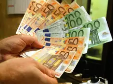 Un uomo tiene in mano alcune banconote di Euro, in una immagine di archivio. ANSA/ETTORE FERRARI/DRN