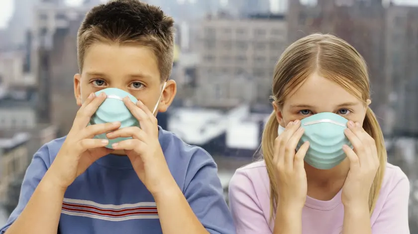 Portrait of a Brother and His Sister Wearing Pollution Masks --- Image by © Ocean/Corbis