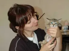Una volontaria dell’Enpa con un micio, e il luogo del ritrovamento