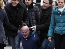 Le forze dell'ordine bloccano uno dei due uomini che hanno minacciato di darsi fuoco vicino al colonnato di San Pietro, 11 febbraio 2014. ANSA/ MASSIMO PERCOSSI